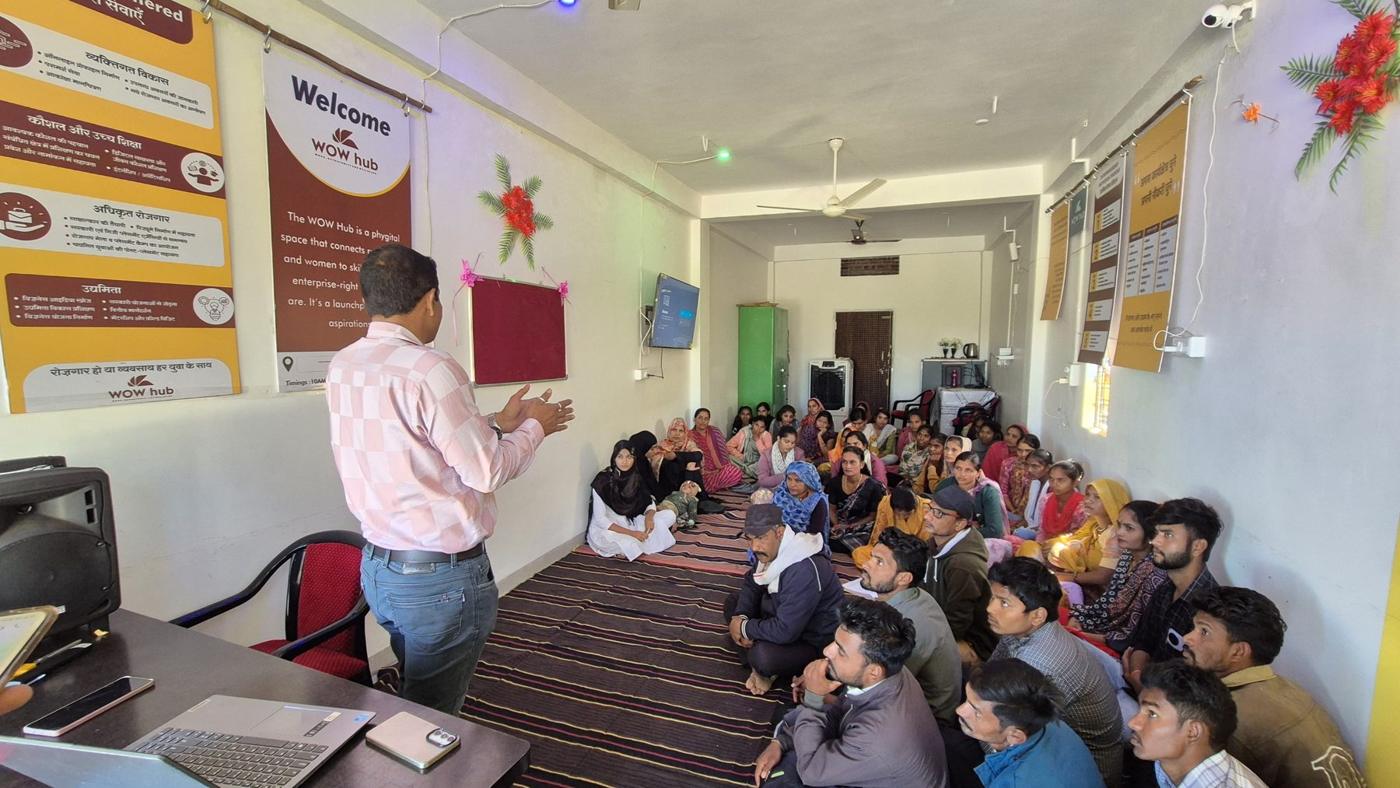 An Apna AI session at a WOW Hub, youth seated on the floor facing a facilitator